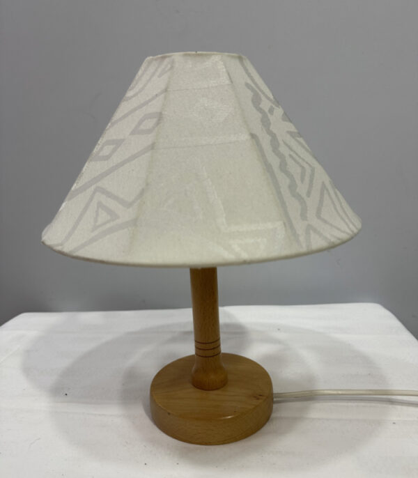 Stilvolle Tischlampe mit Holzfuss und Stoffschirm im geometrischen Ethno-Muster