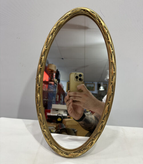 Ovaler Wandspiegel mit goldfarbenem Rahmen