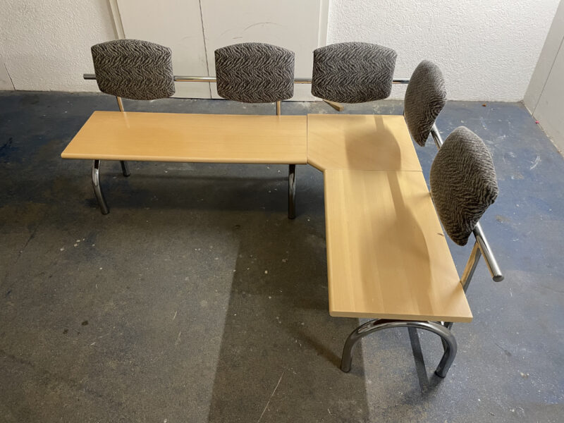 L-förmige Sitzbank mit gepolsterten Lehnen – stabile Metallkonstruktion und helle Holzsitzflächen