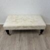 Vintage Hocker mit hellem Stoffbezug und Rollen
