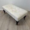 Vintage Hocker mit hellem Stoffbezug und Rollen
