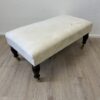 Vintage Hocker mit hellem Stoffbezug und Rollen