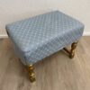 Polsterhocker blau mit Muster und goldfarbenen Beinen
