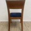 Moderner Esszimmerstuhl mit blau gepolsterter Sitzfläche