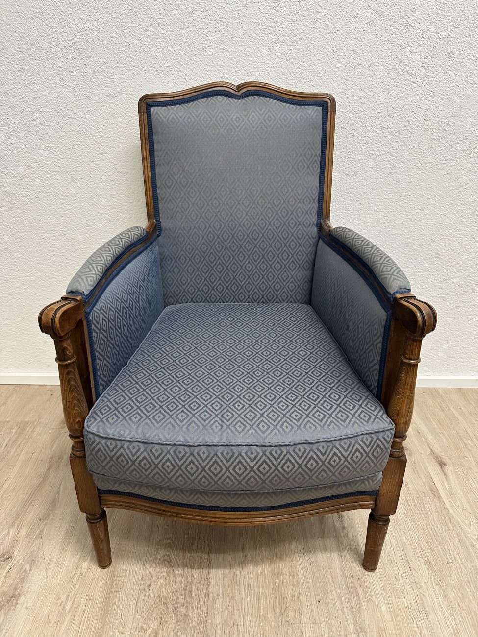 Vintage Sessel mit blau gemustertem Stoffbezug und Holzfüssen