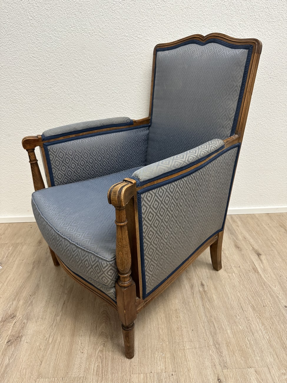 Vintage Sessel mit blau gemustertem Stoffbezug und Holzfüssen