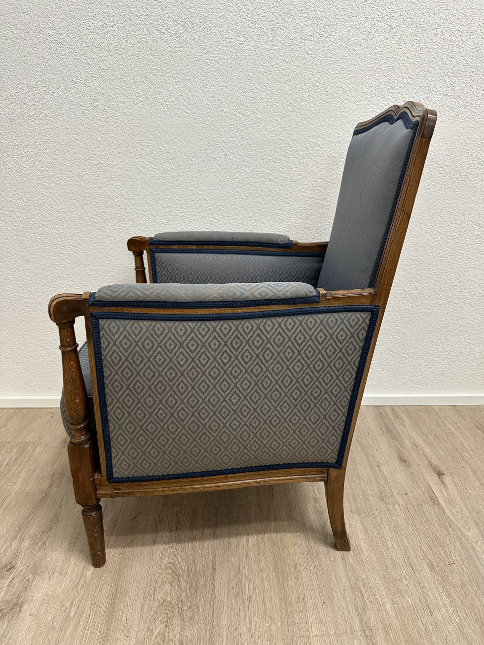Vintage Sessel mit blau gemustertem Stoffbezug und Holzfüssen