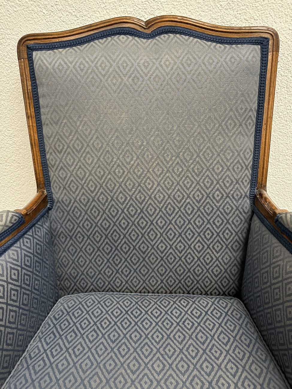 Vintage Sessel mit blau gemustertem Stoffbezug und Holzfüssen