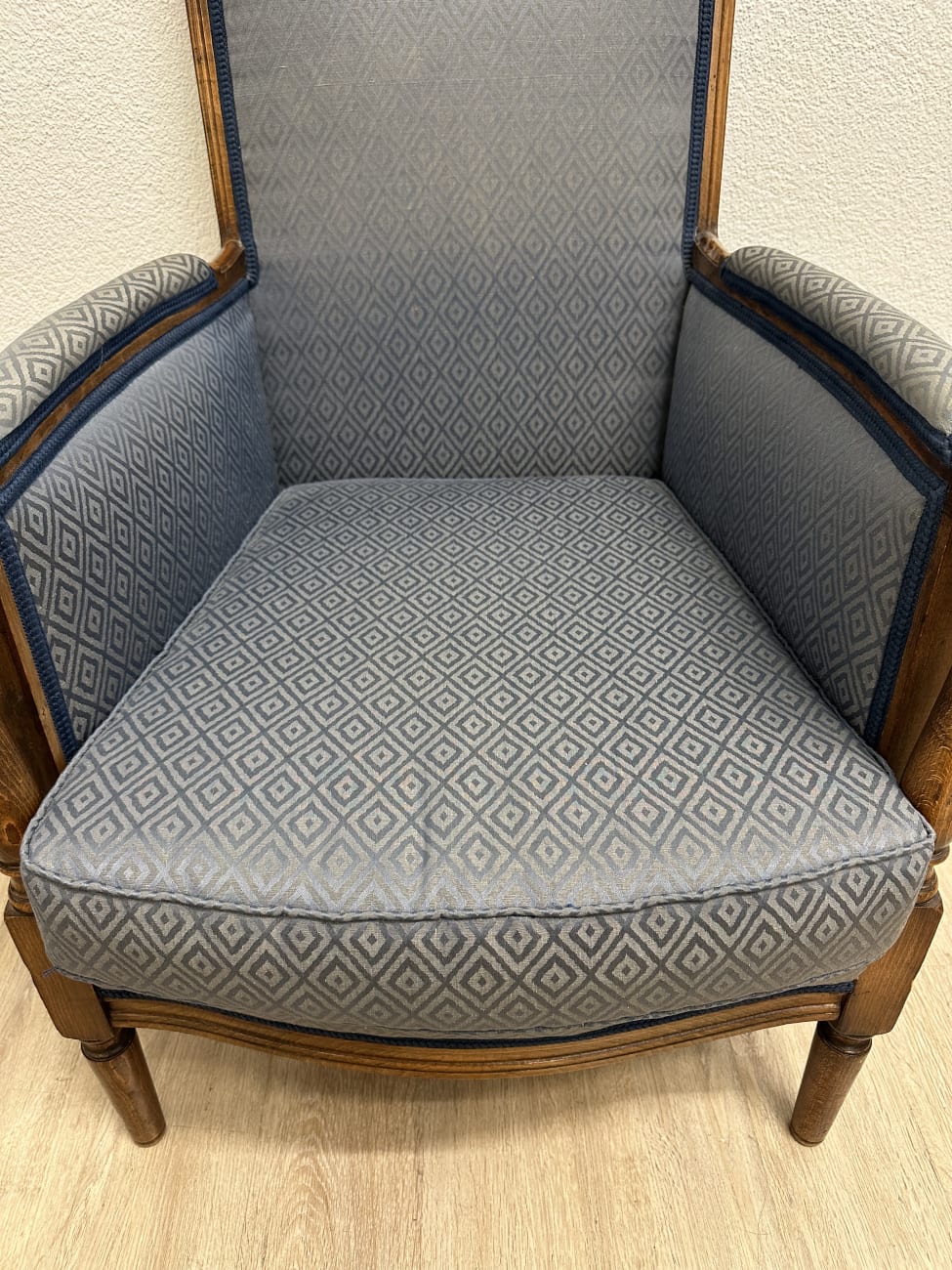 Vintage Sessel mit blau gemustertem Stoffbezug und Holzfüssen