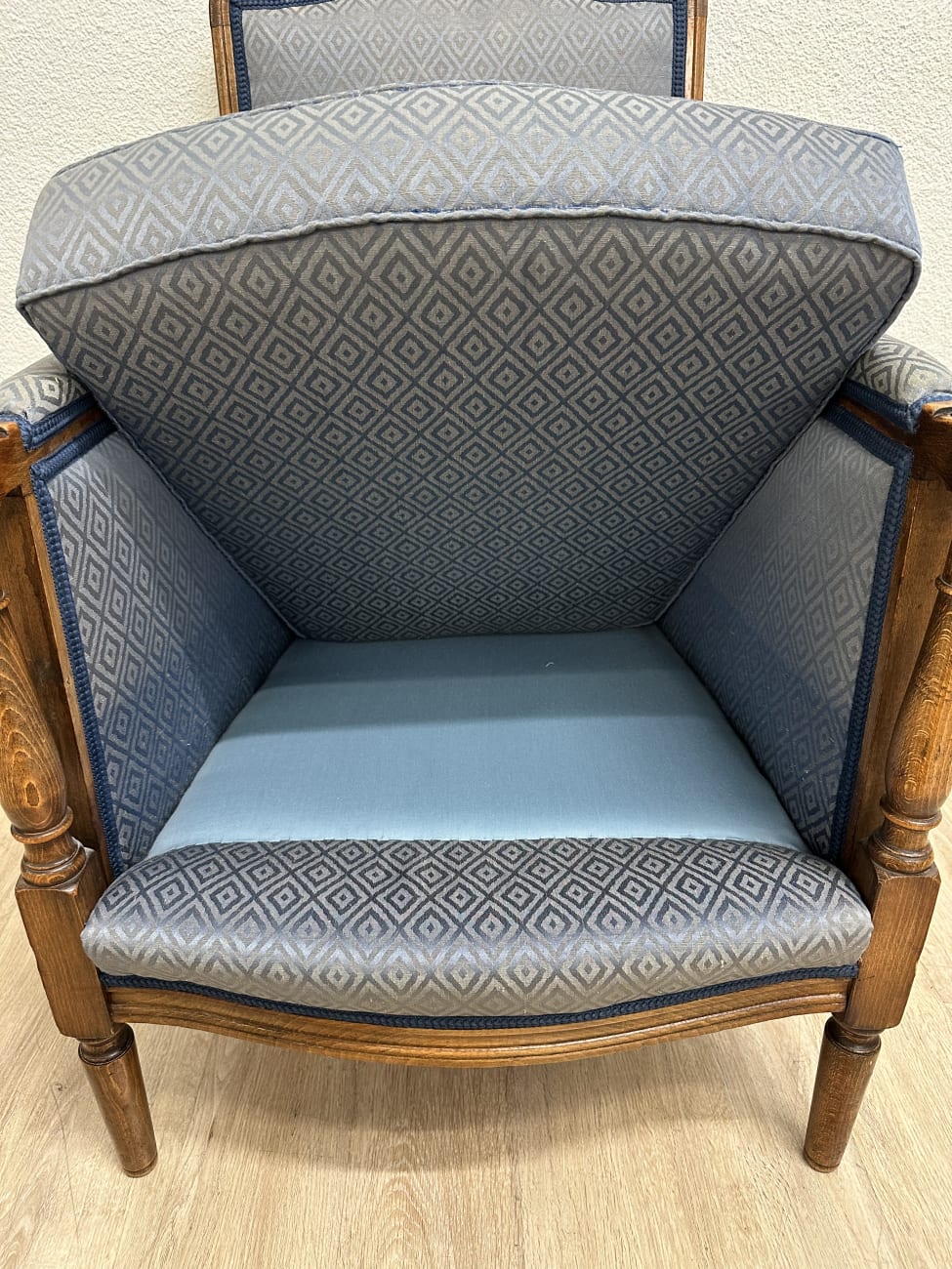 Vintage Sessel mit blau gemustertem Stoffbezug und Holzfüssen