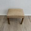 Vintage Polsterhocker mit floralem Stoffbezug und Holzbeinen