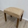Vintage Polsterhocker mit floralem Stoffbezug und Holzbeinen