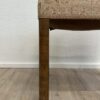 Vintage Polsterhocker mit floralem Stoffbezug und Holzbeinen